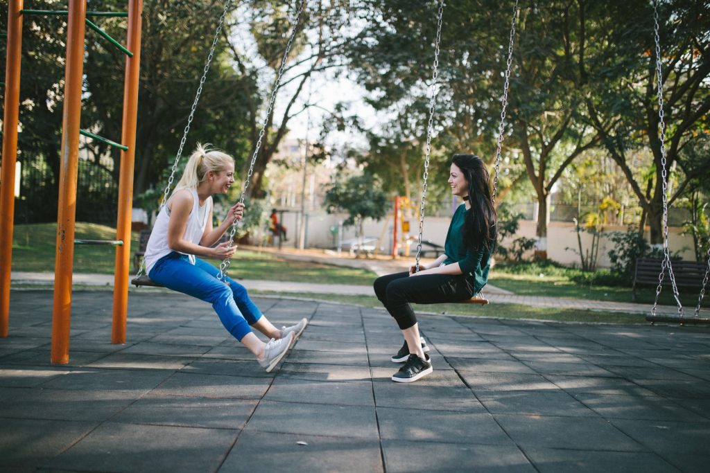 Two women in conversation at a park. Many English listening exercises can be done with partners.