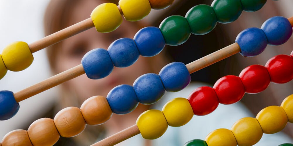 A toy abacus with the blurred image of a girl in the background
