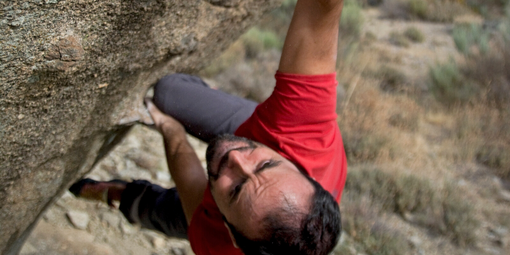A man is climbing a rock in the desert