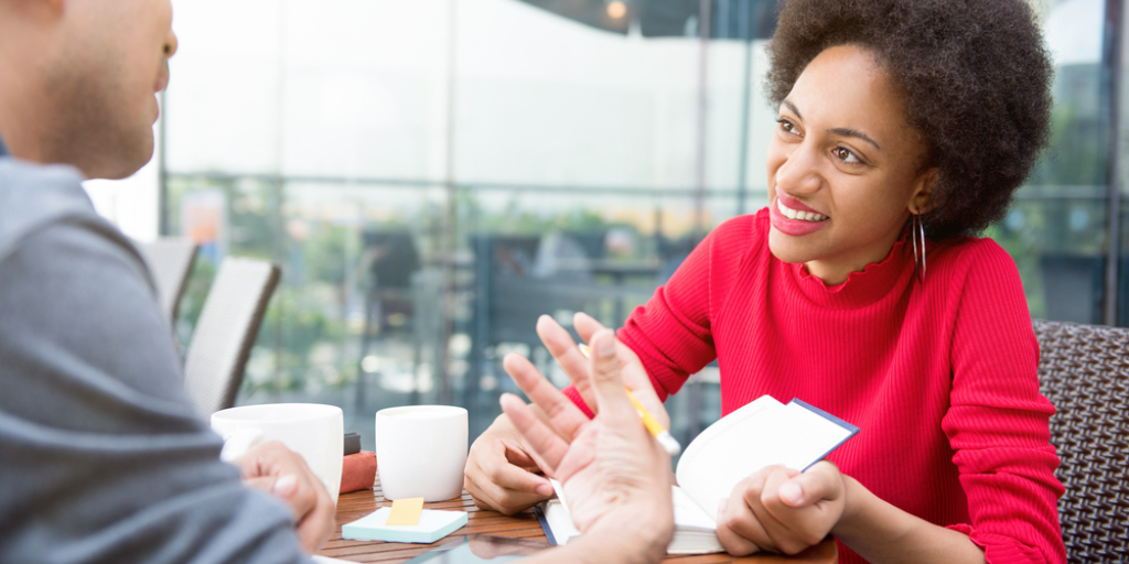 A woman listening to her friend talking while sitting in cafe