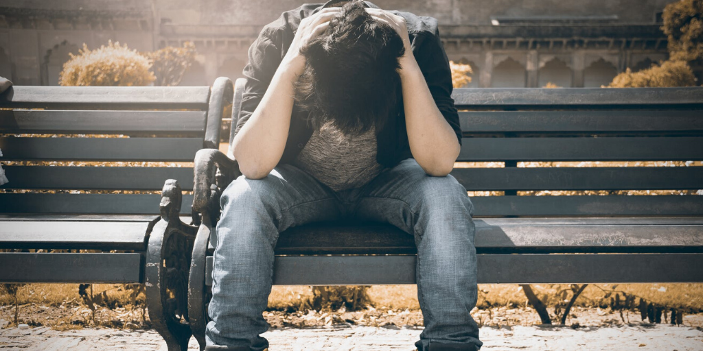 A man on a bench shows frustration