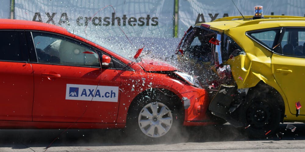 A red car crashes into a yellow car in a crash test