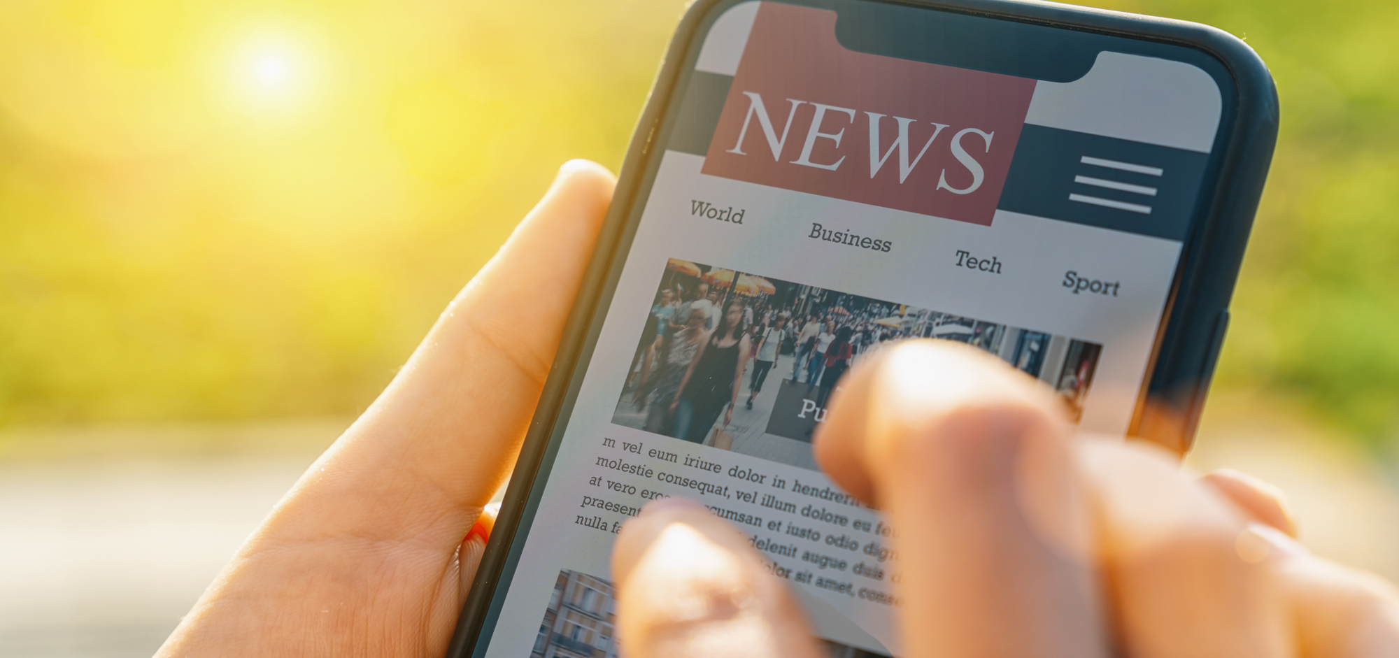 A person holds a phone displaying a news app. News apps are a great way to learn English with current events.