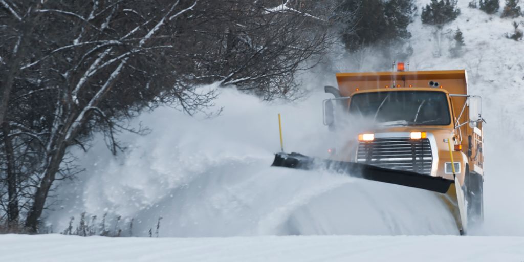A snowplow pushing several inches of recently-fallen snow