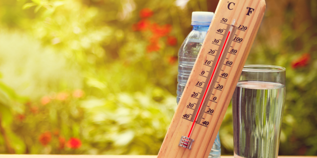 A thermometer placed near a bottle of water shows a heat wave reaching 45 degrees Celsius.
