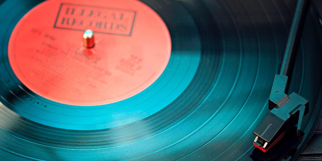 A blue-tinted vinyl record plays