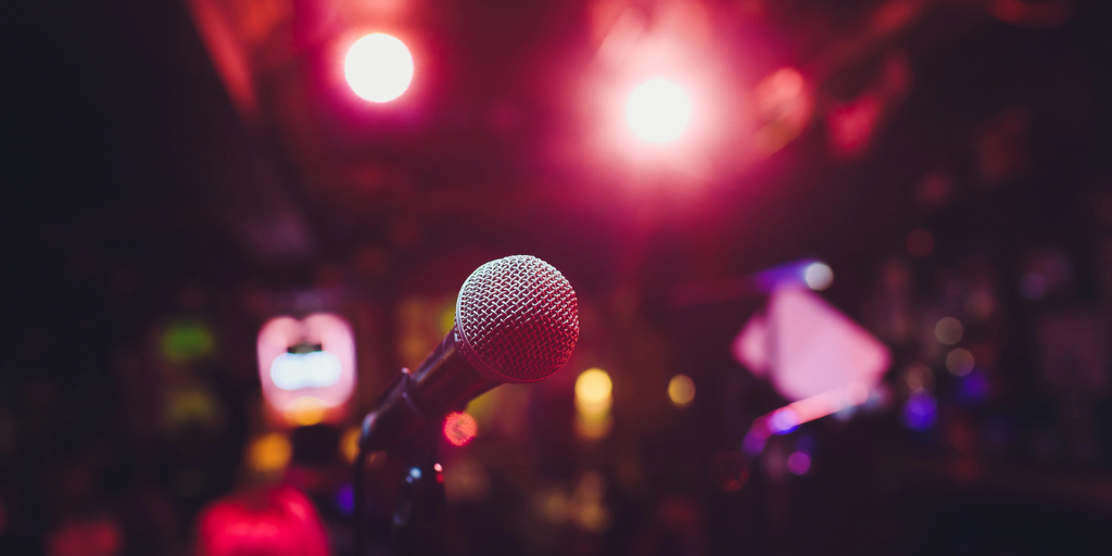 A microphone with blurred background of an audience