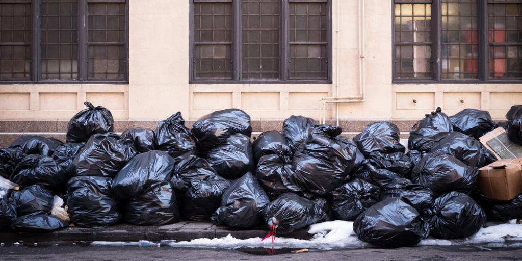Dozens of trash bags piled on the sidewalk in New York City