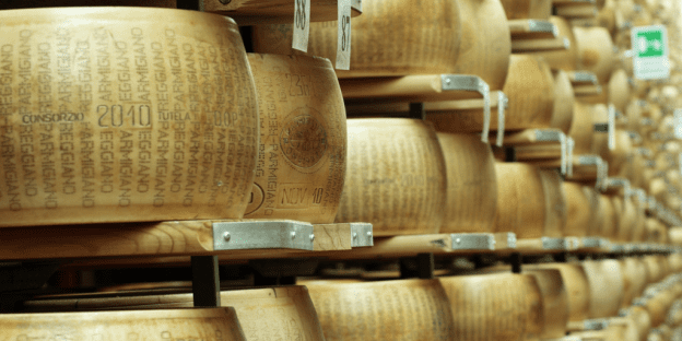 Wheels of Parmigiano Reggiano cheese in an ageing warehouse