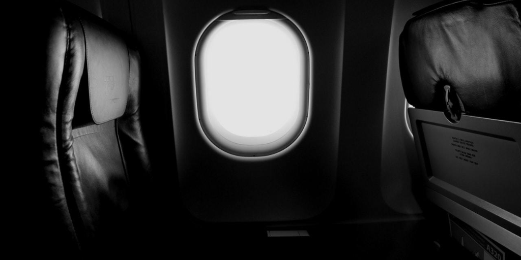 Light shines into an airplane cabin through an oval window