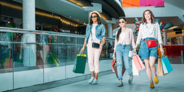 Three women with shopping bags at an indoor mall
