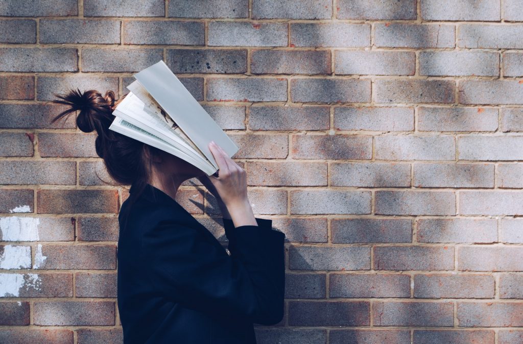 A woman is clearly confused by a technical book she is reading.